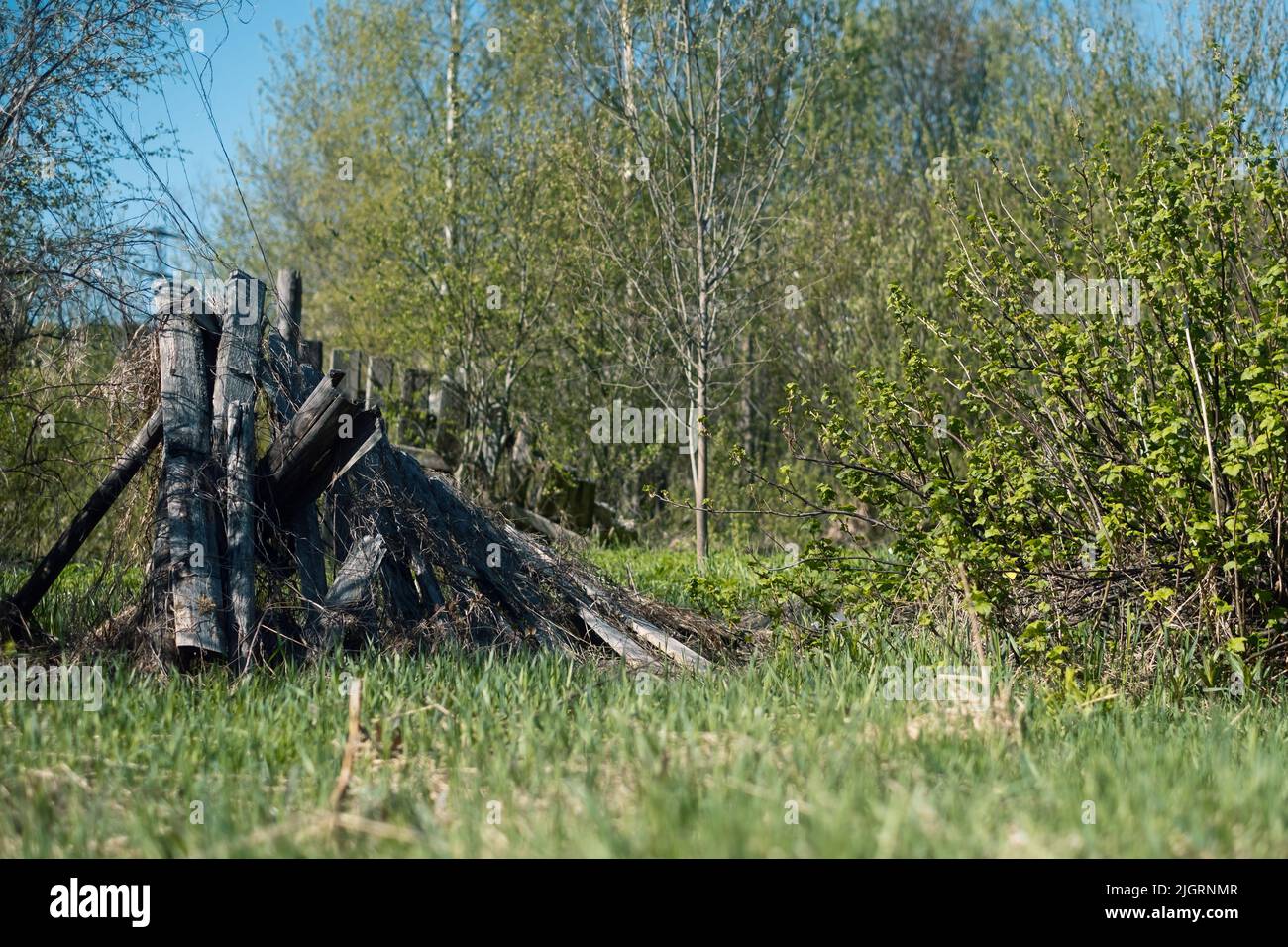 Ruined destroyed fence in village on summer day Stock Photo