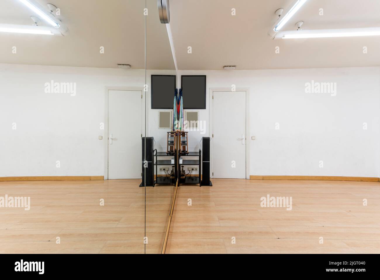 Exercise room with hardwood floors and a mirrored wall and stereo with
