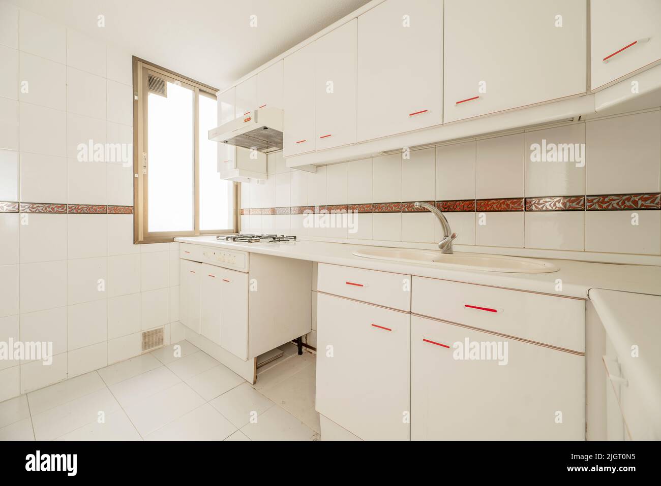 Kitchen with white furniture and red details, countertop and appliances of the same color and