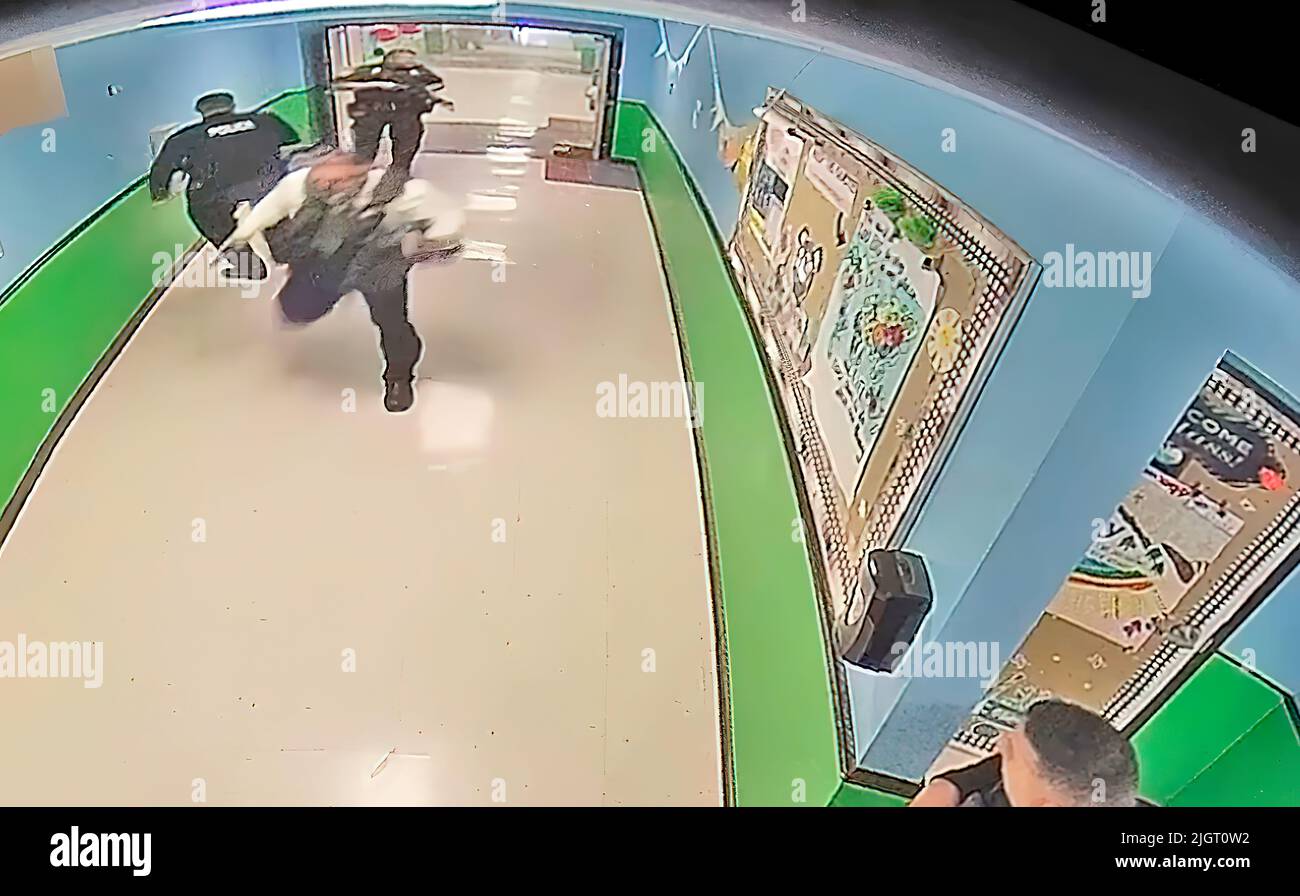 A frame from a school surveillance video shows multiple police officers running from gunfire in a hallway at Robb Elementary School. The police waited nearly an hour and a half before entering the school room where the gunman was located. (Photo: Uvalde Investigative Files) Stock Photo