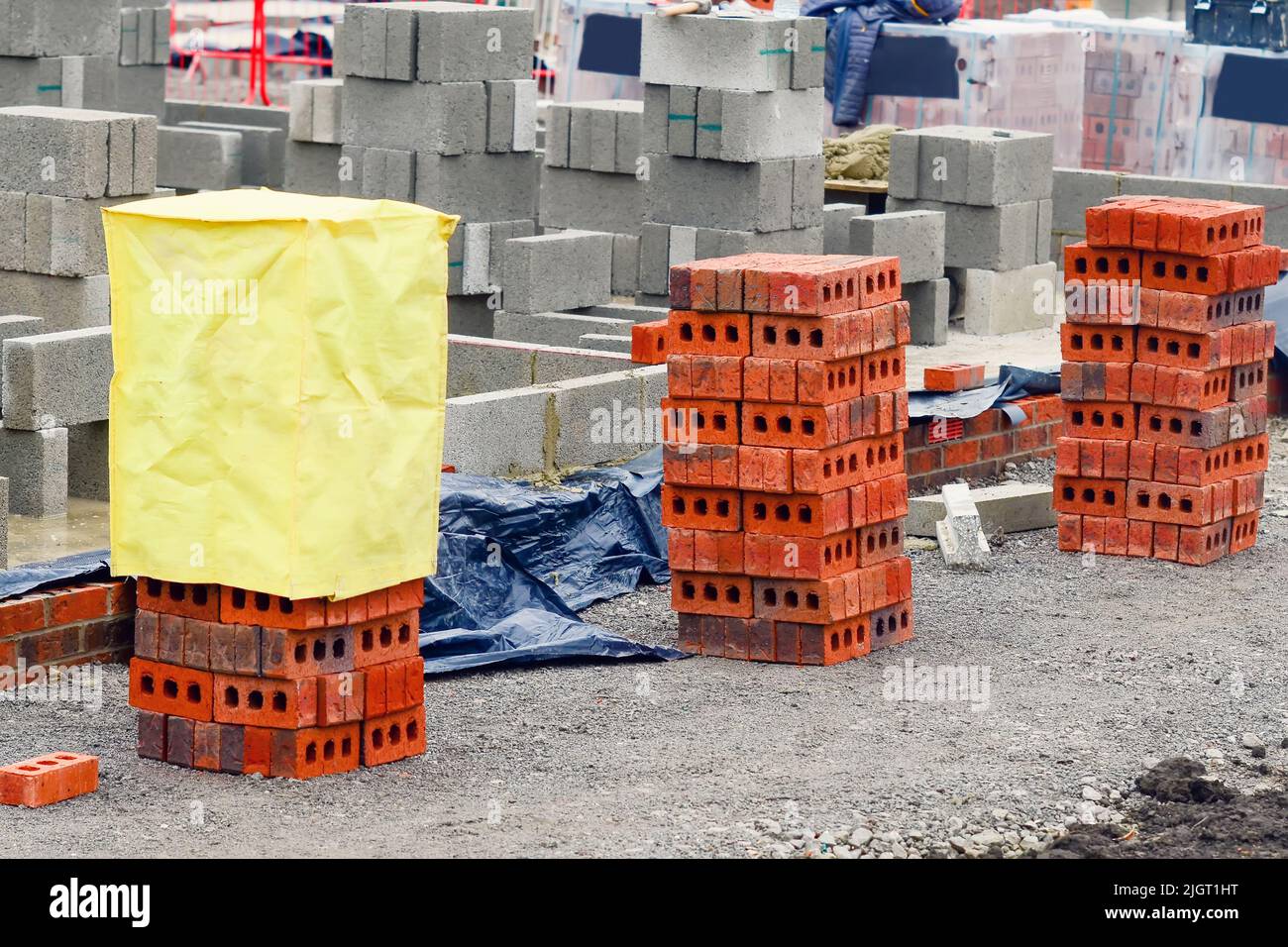 Red bricks and concrete blocks delivered on construction site and placed next to place of work ready for bricklayers Stock Photo