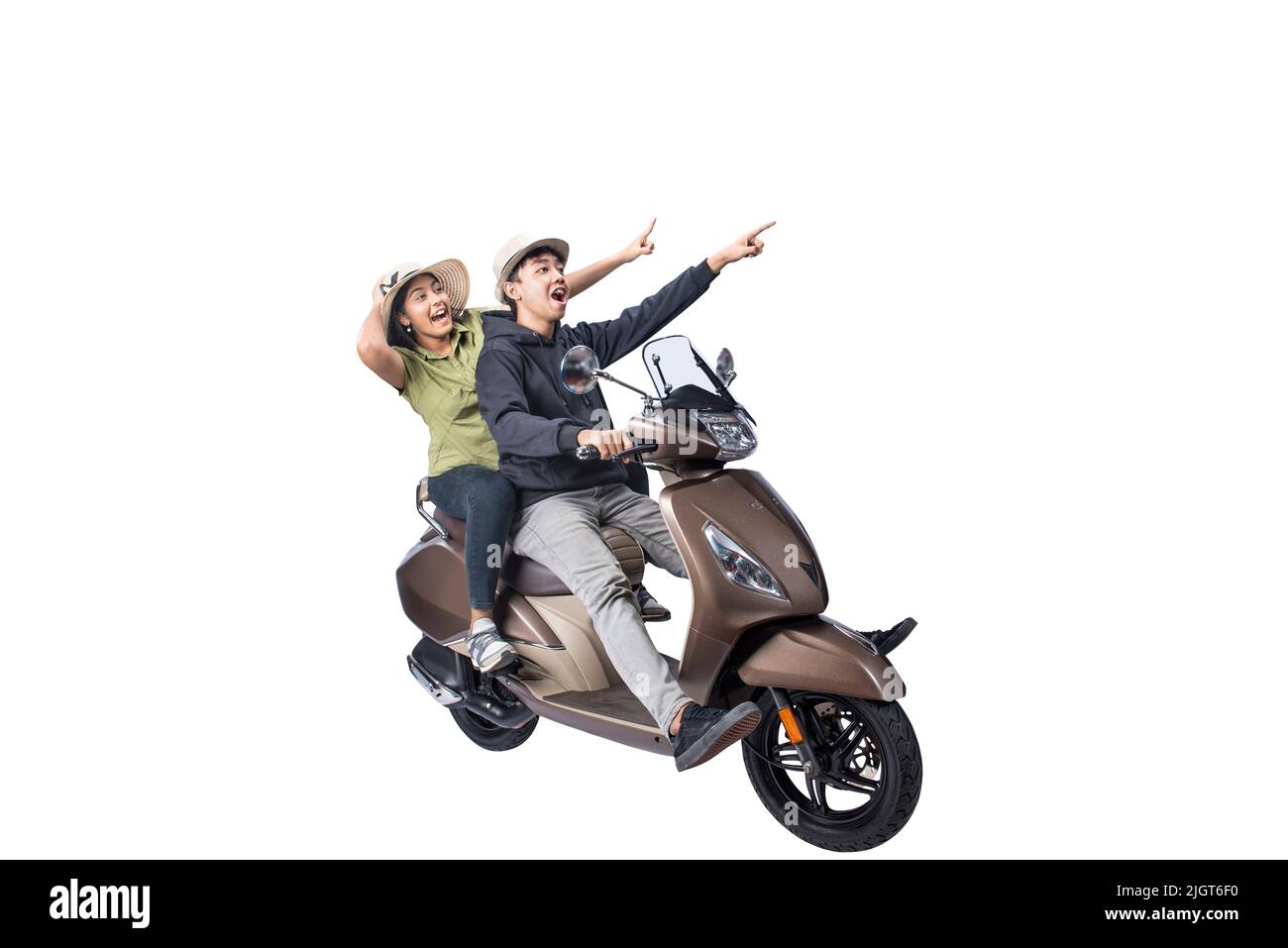 An Asian couple with a hat is sitting on a scooter and pointing something isolated over white background Stock Photo