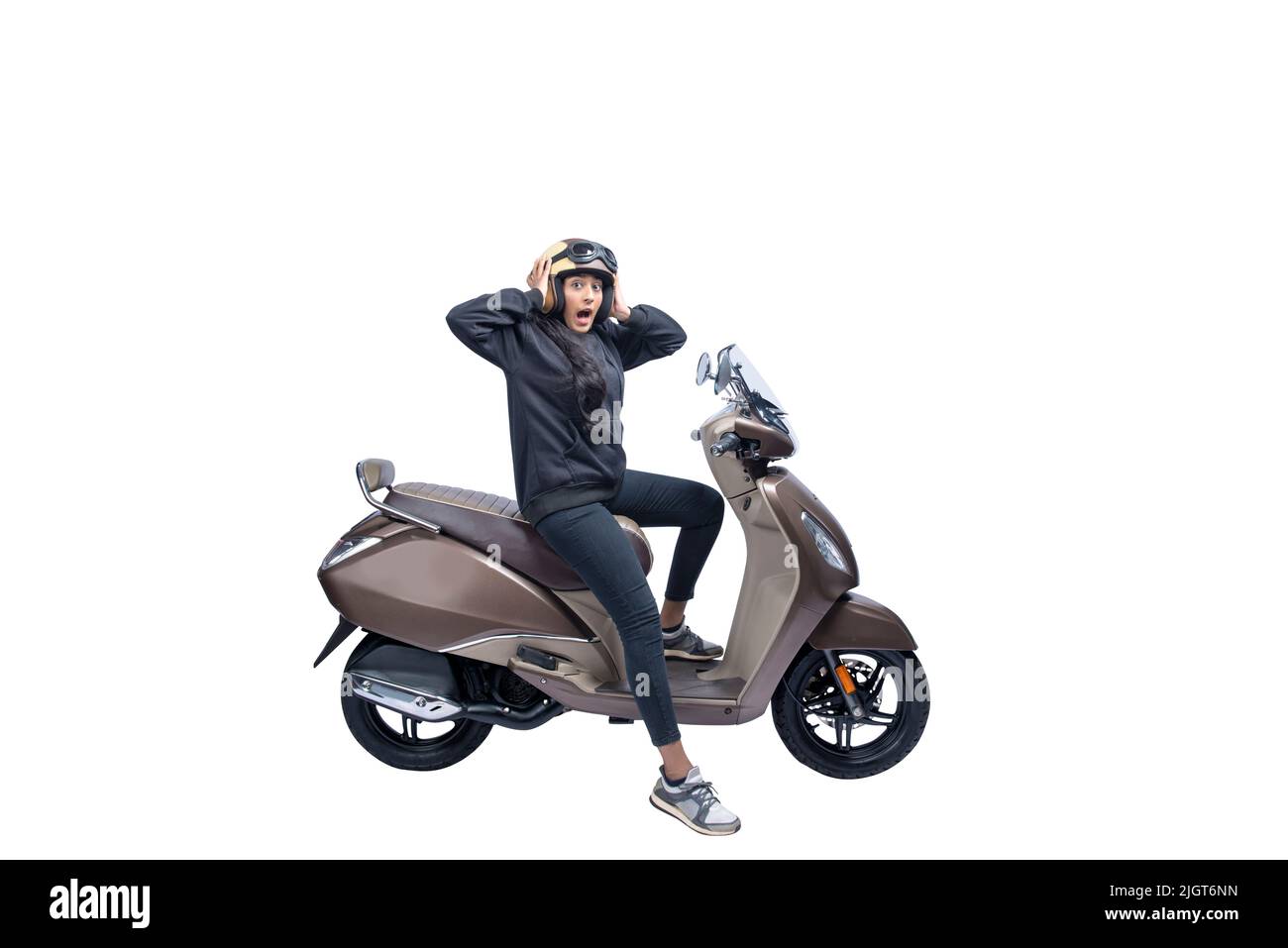 Asian woman with a helmet and jacket sitting on a scooter with a shocked expression isolated over white background Stock Photo