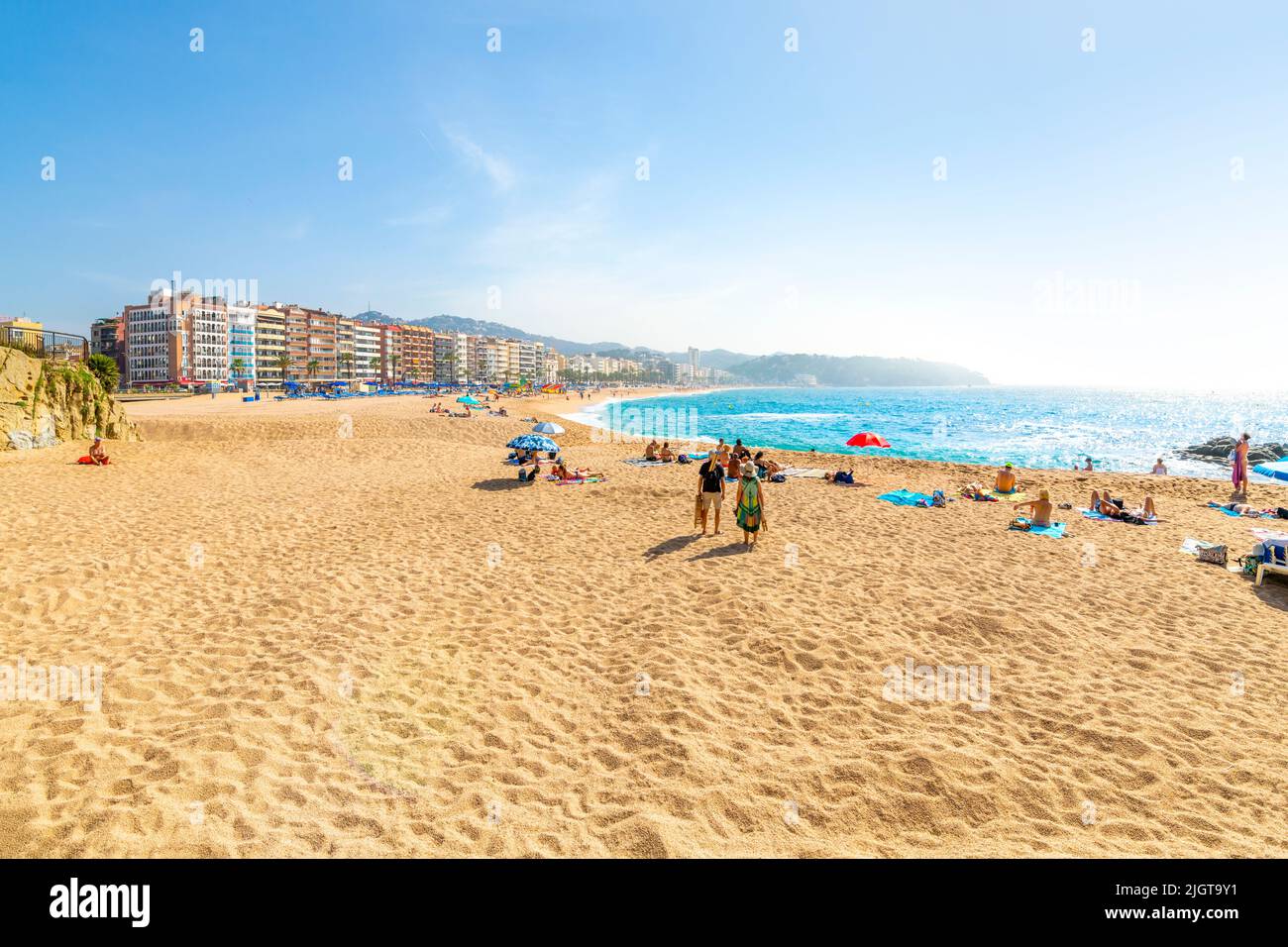 The sandy beach along the Costa Brava coast of the Mediterranean Sea at the resort town of Lloret de Mar, Spain. Stock Photo