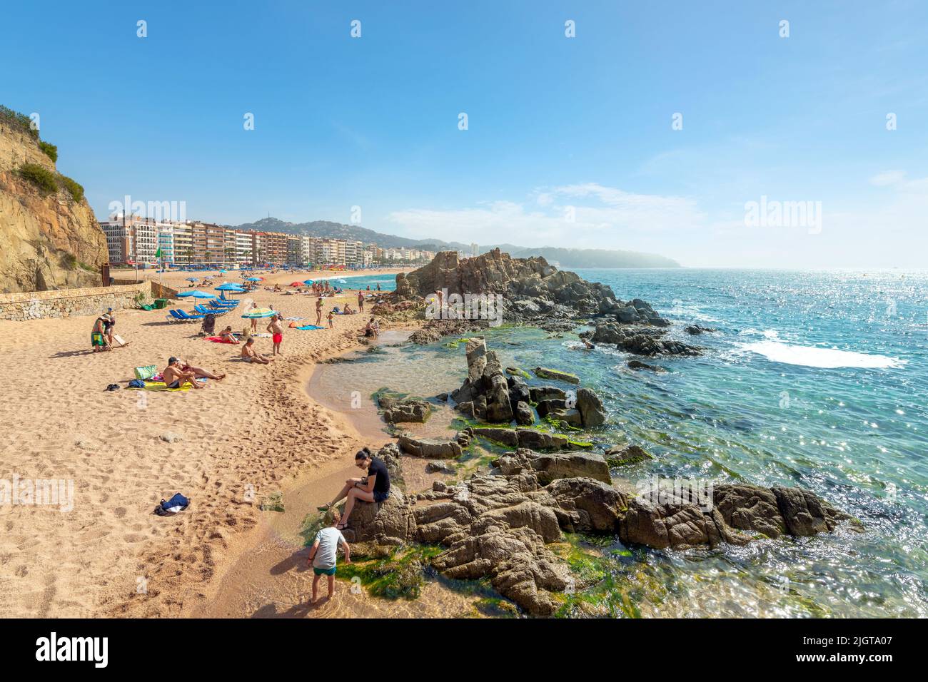 Spanish families enjoy a summer day at the sandy beach of Lloret de Mar on the Costa Brava coast of Southern Spain. Stock Photo