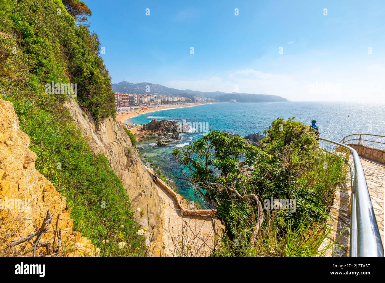 View of the sandy beach, rocky shoreline and resort town of Lloret de Mar, Spain, on the Costa Brava coast of the Mediterranean Sea. Stock Photo