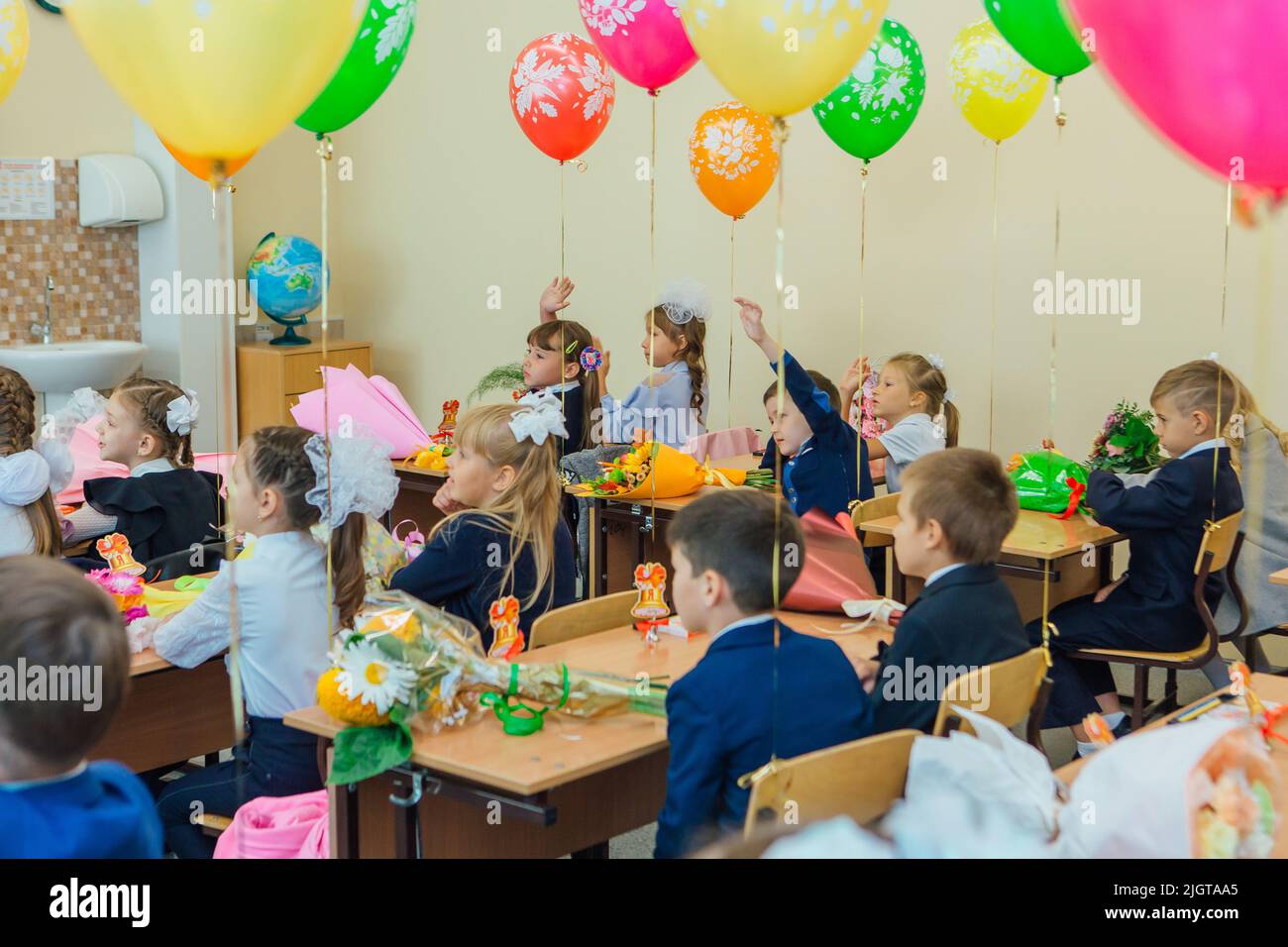 NOVOKUZNETSK, KEMEROVO REGION, RUSSIA - SEP, 1, 2021: First-grade students and teacher are in school classroom at first lesson. The day of knowledge i Stock Photo