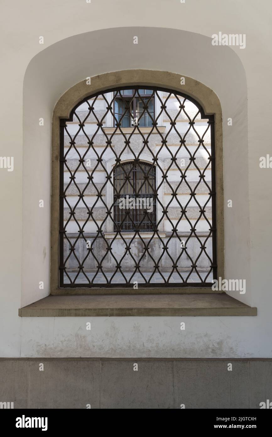 Close up of barred old window through which historical facade of old building in Vienna Austria can be seen as concept for being locked up and prison Stock Photo