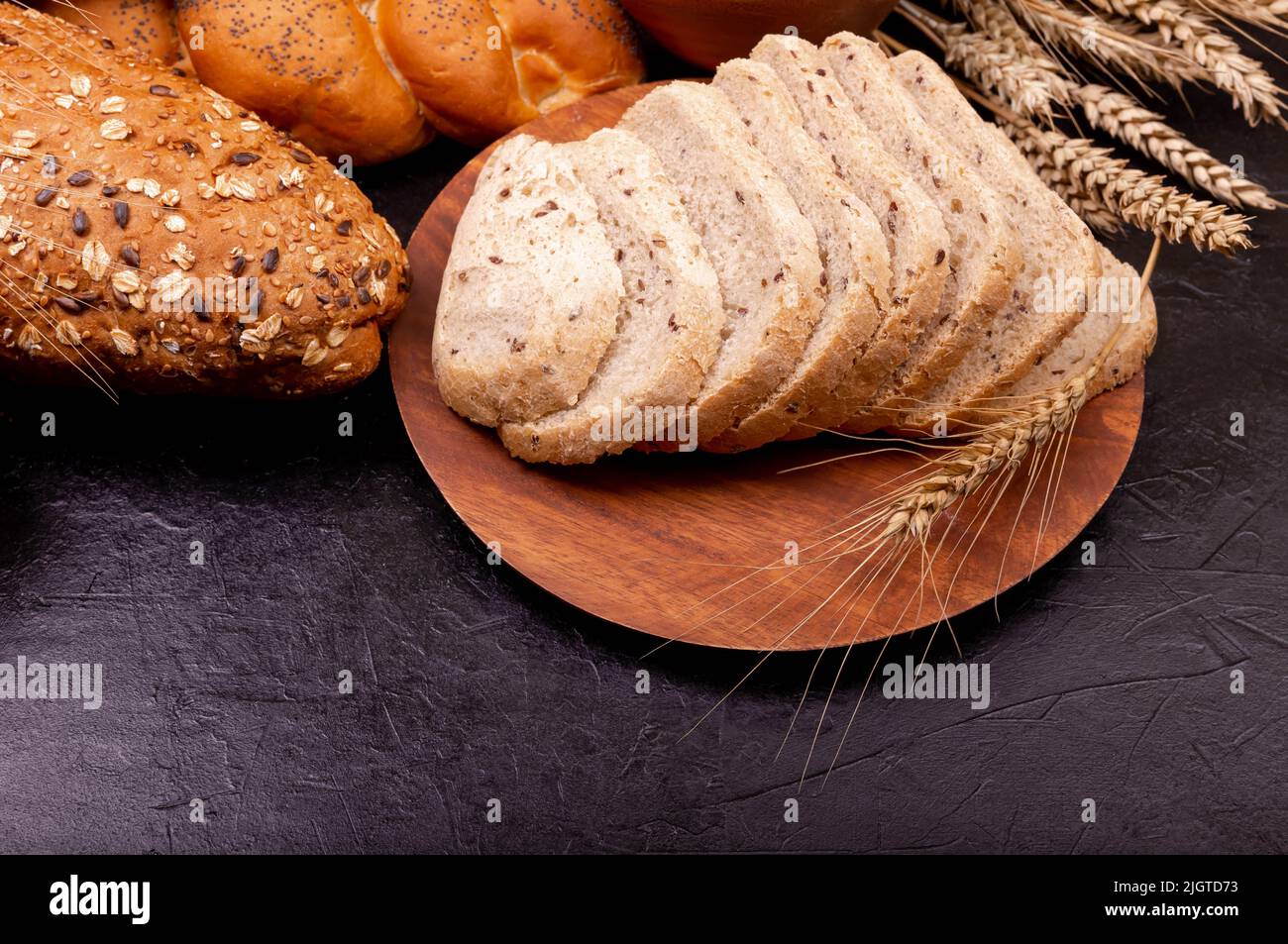 Top view of sliced whole grain bread on dark rustic wooden background ...