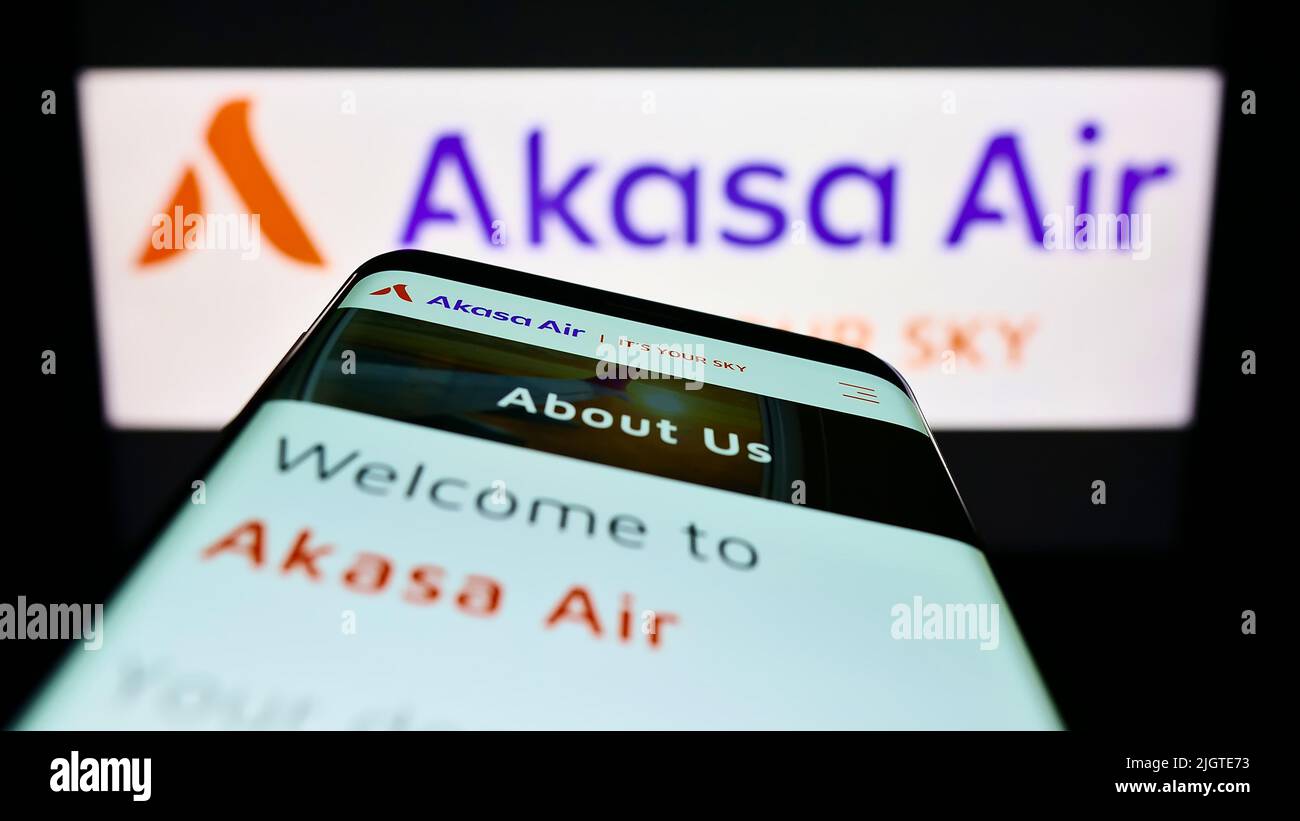 Smartphone with website of airline SNV Aviation Private Limited (Akasa Air) on screen in front of logo. Focus on top-left of phone display. Stock Photo