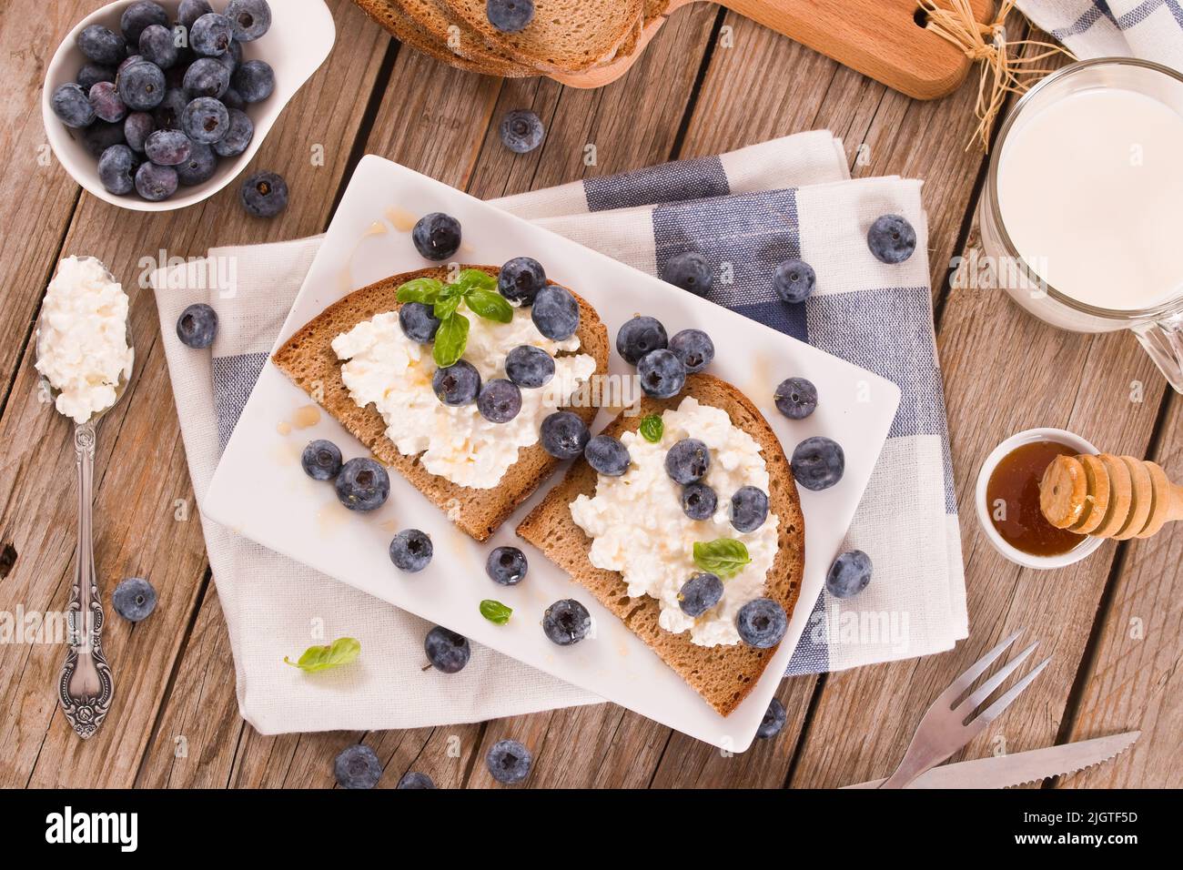 Rye bread with cottage cheese, blueberries and honey Stock Photo Alamy