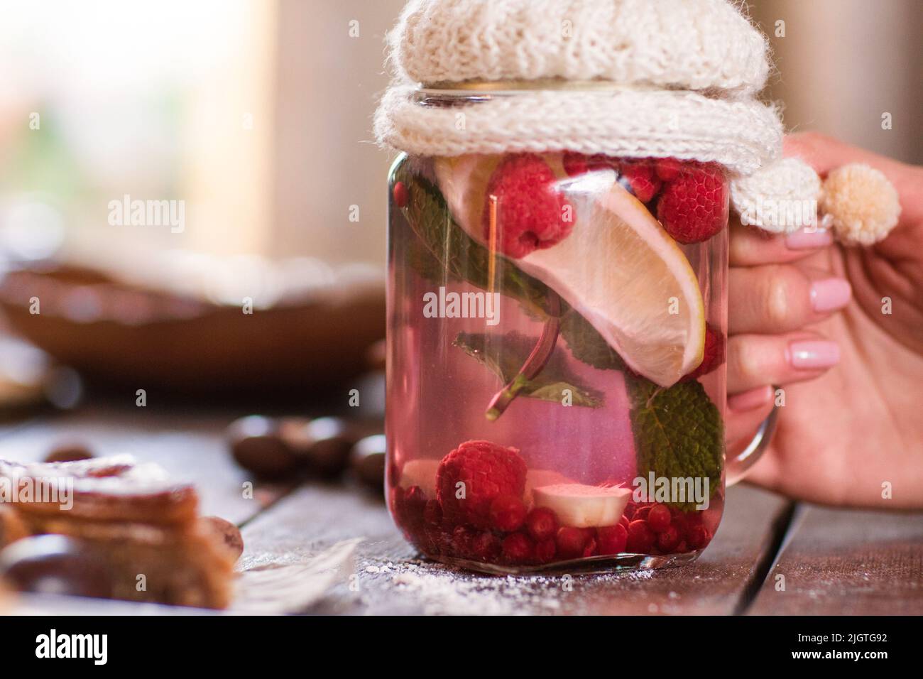Woman taking glass jar with natural tea free space Stock Photo