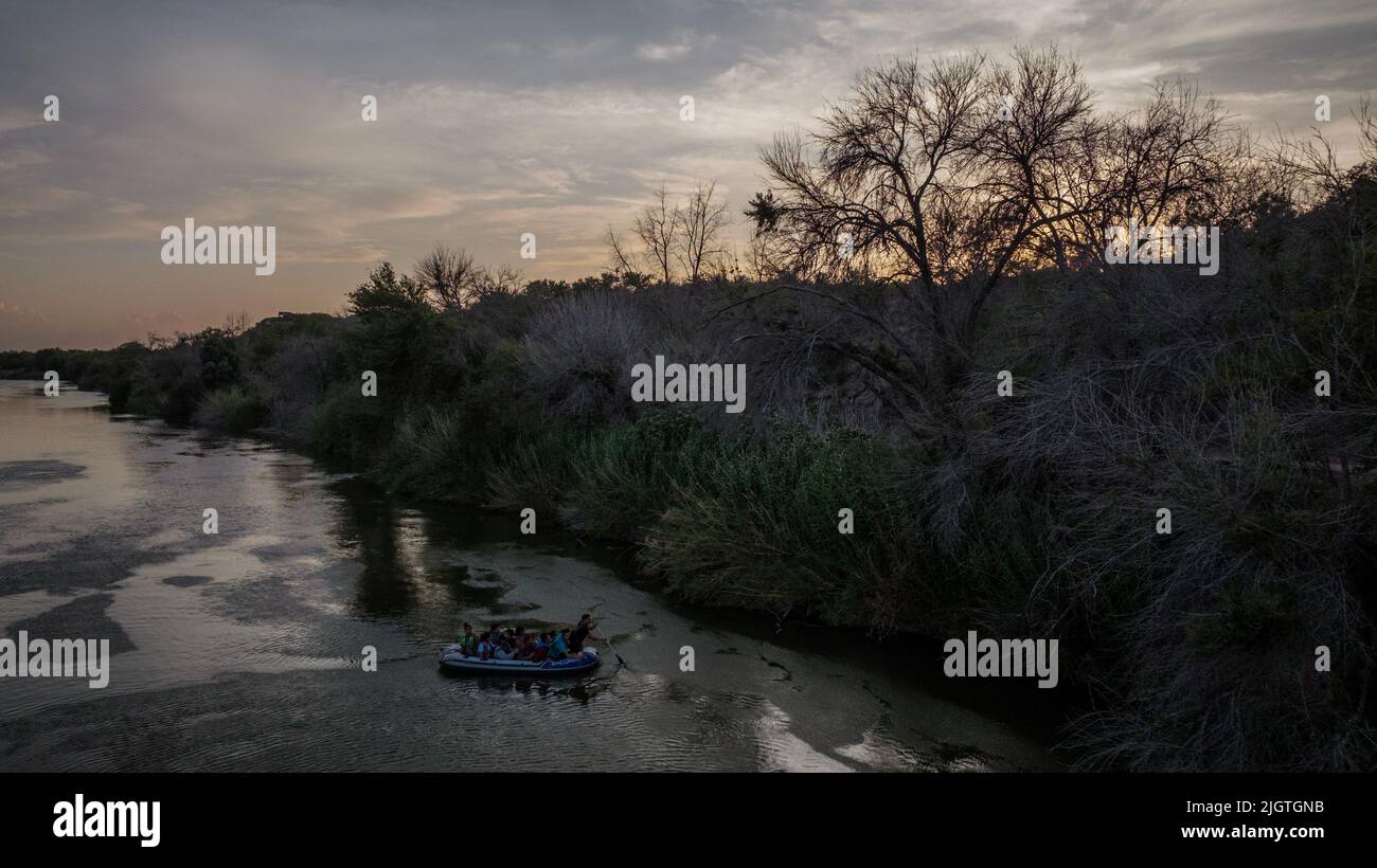 A smuggler uses a raft to transport migrant families across the Rio Grande river into the U.S. from Mexico, in Roma Creek, Texas, U.S., July 12, 2022.  REUTERS/Adrees Latif     TPX IMAGES OF THE DAY Stock Photo