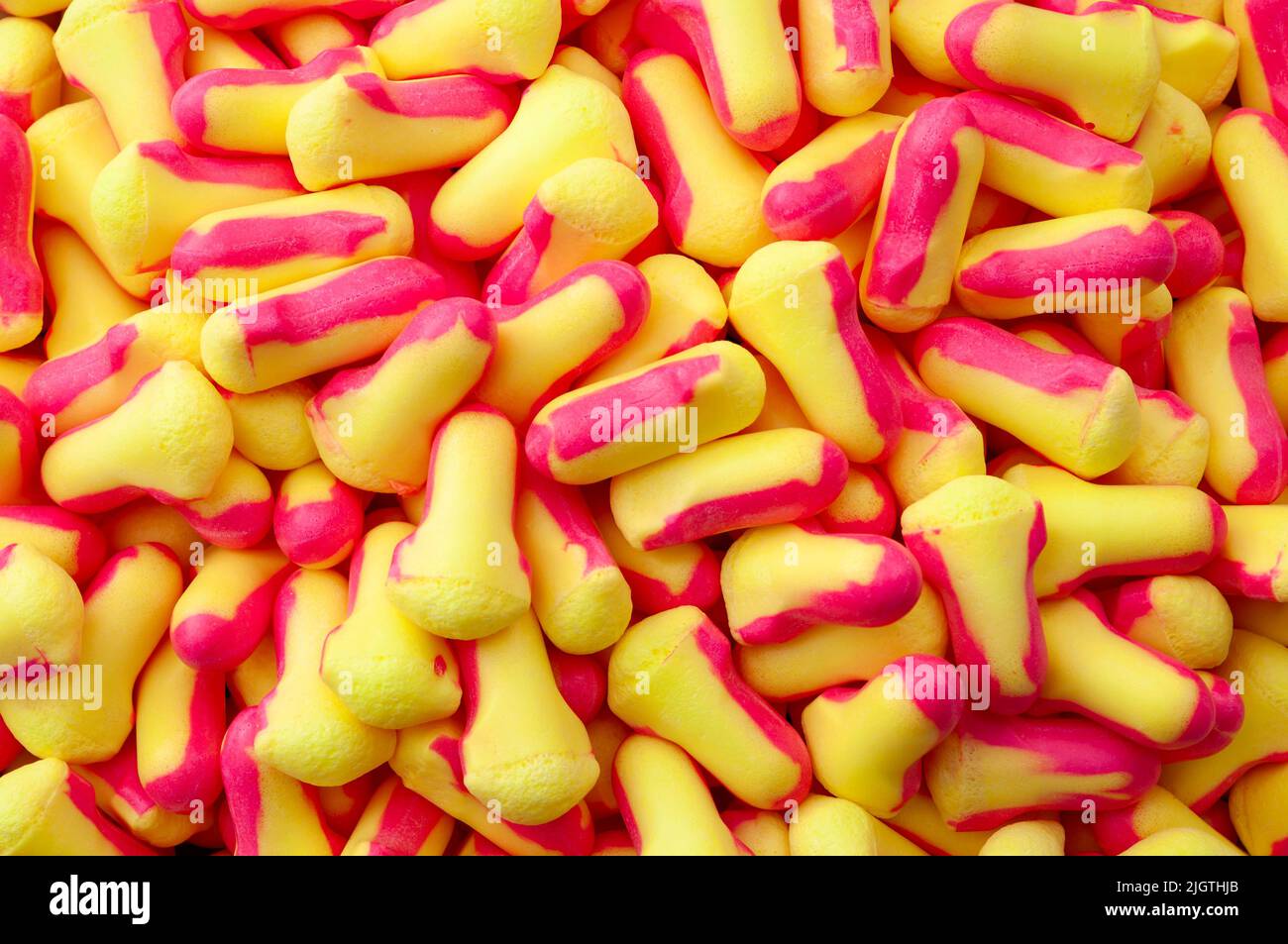Full frame background image of multiple soft foam earplugs scattered concept for Hearing protection equipment, industrial PPE backgrounds and noise re Stock Photo