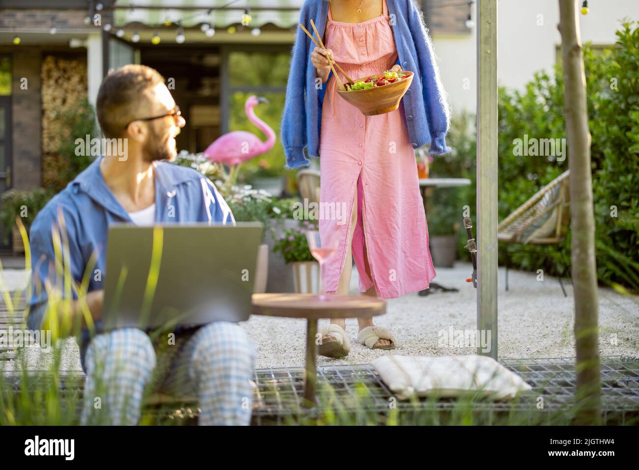 Happy young family with laptop and healthy lunch at backyard Stock Photo