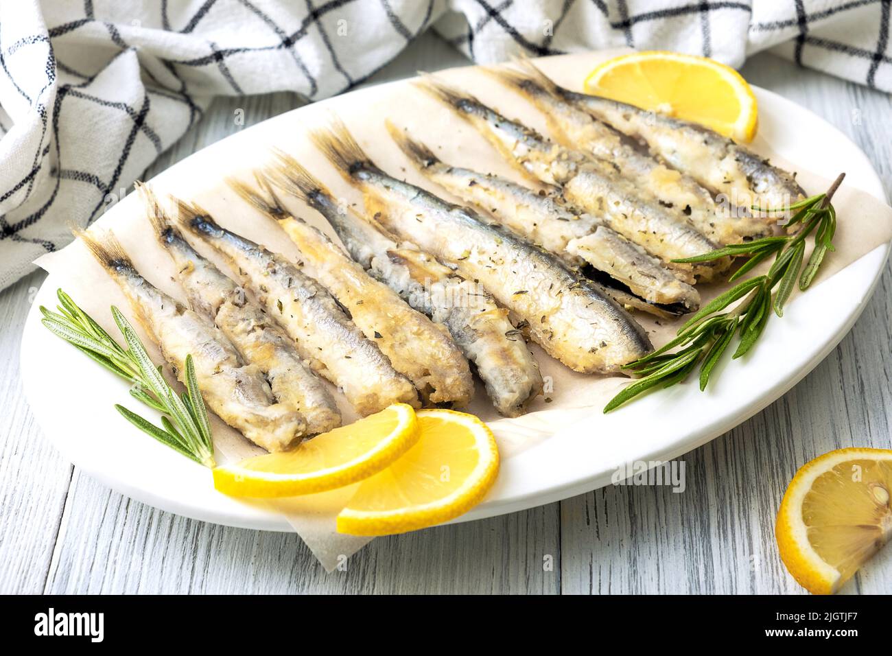 Fried capelin on a white porcelain dish Stock Photo