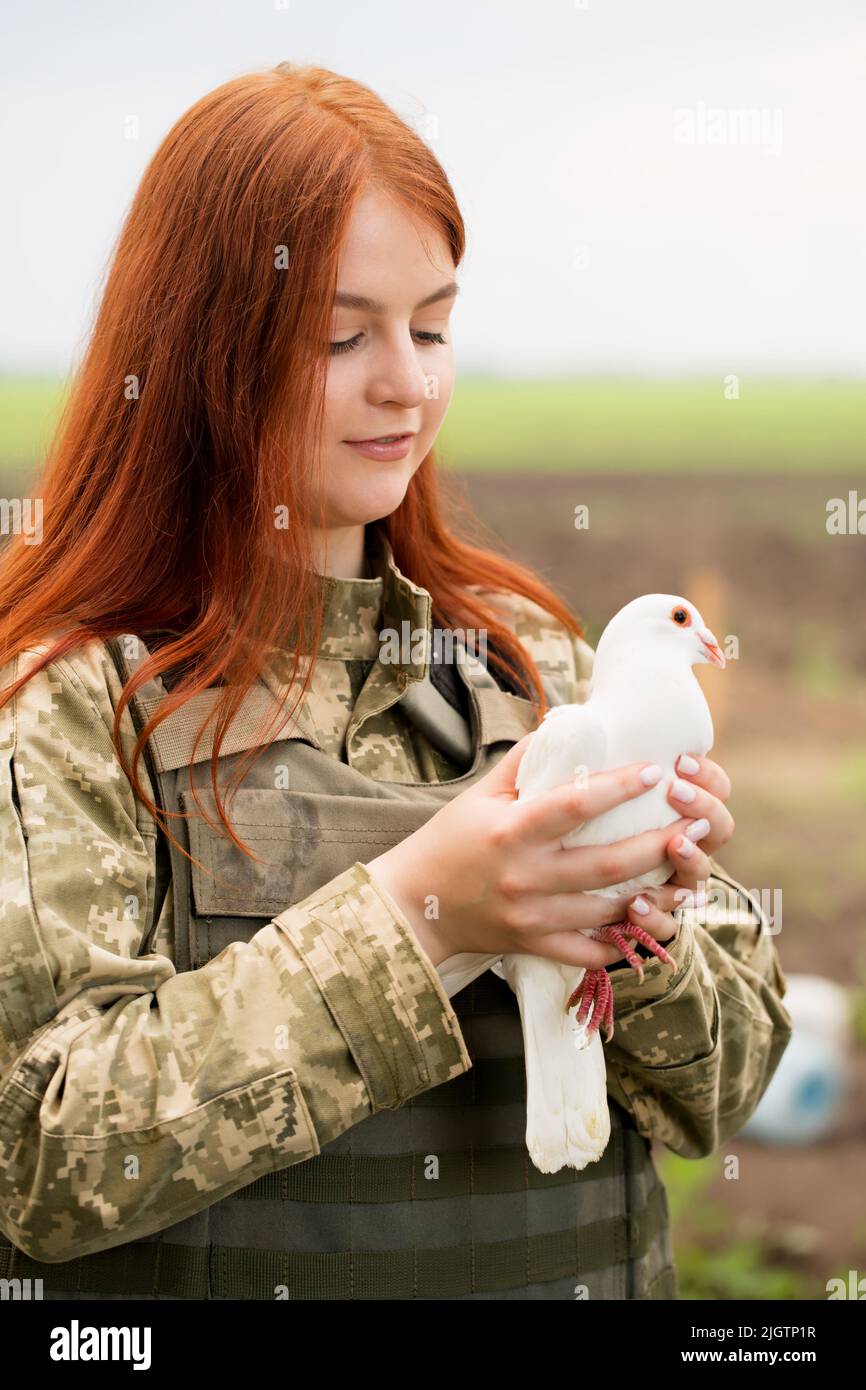 A beautiful Ukrainian young woman in a bulletproof vest with a white