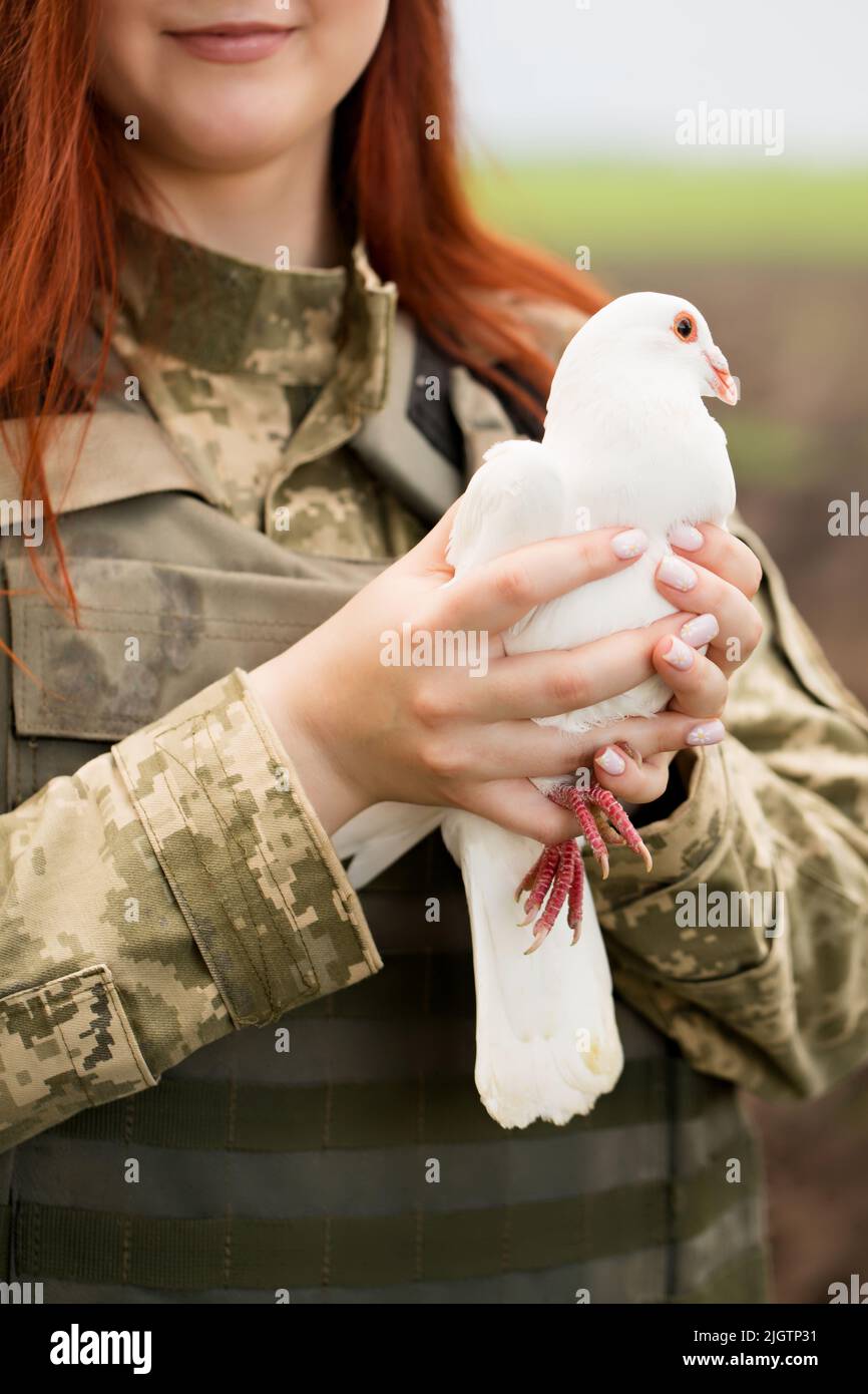 A beautiful Ukrainian young woman in a bulletproof vest with a white