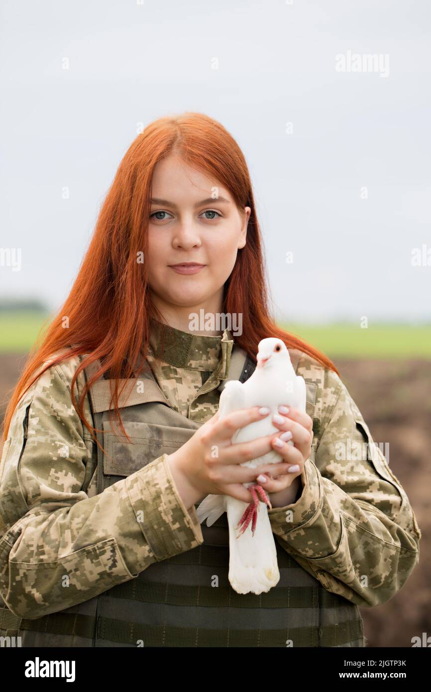 A beautiful Ukrainian young woman in a bulletproof vest with a white