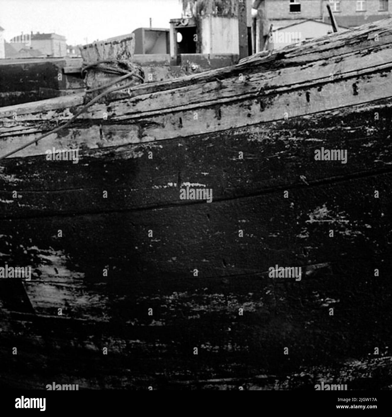 One long side of a boat. You see the table planks and mooring rope. In ...