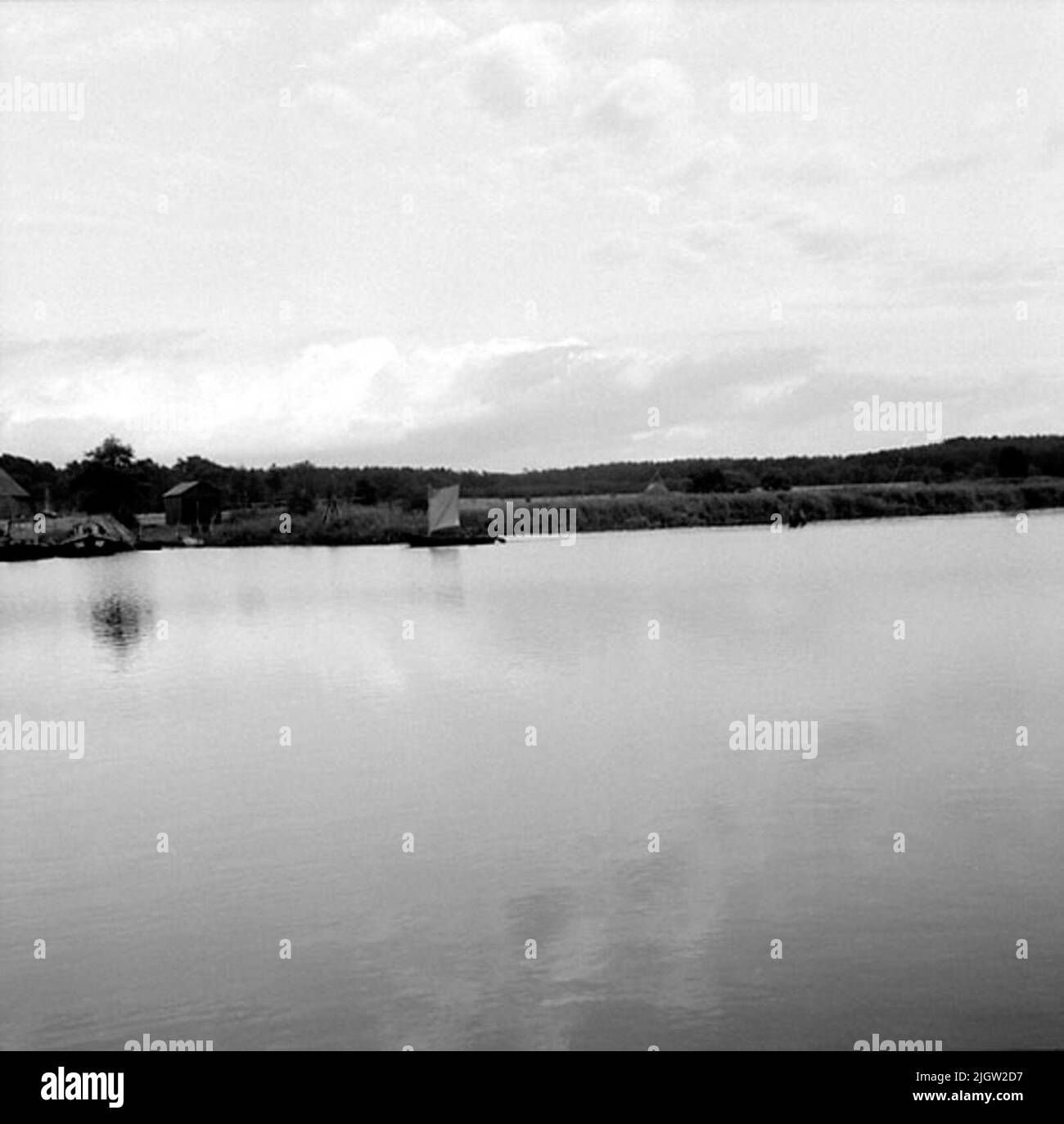 A boat sails into a marina on the other side of a bay Stock Photo Alamy