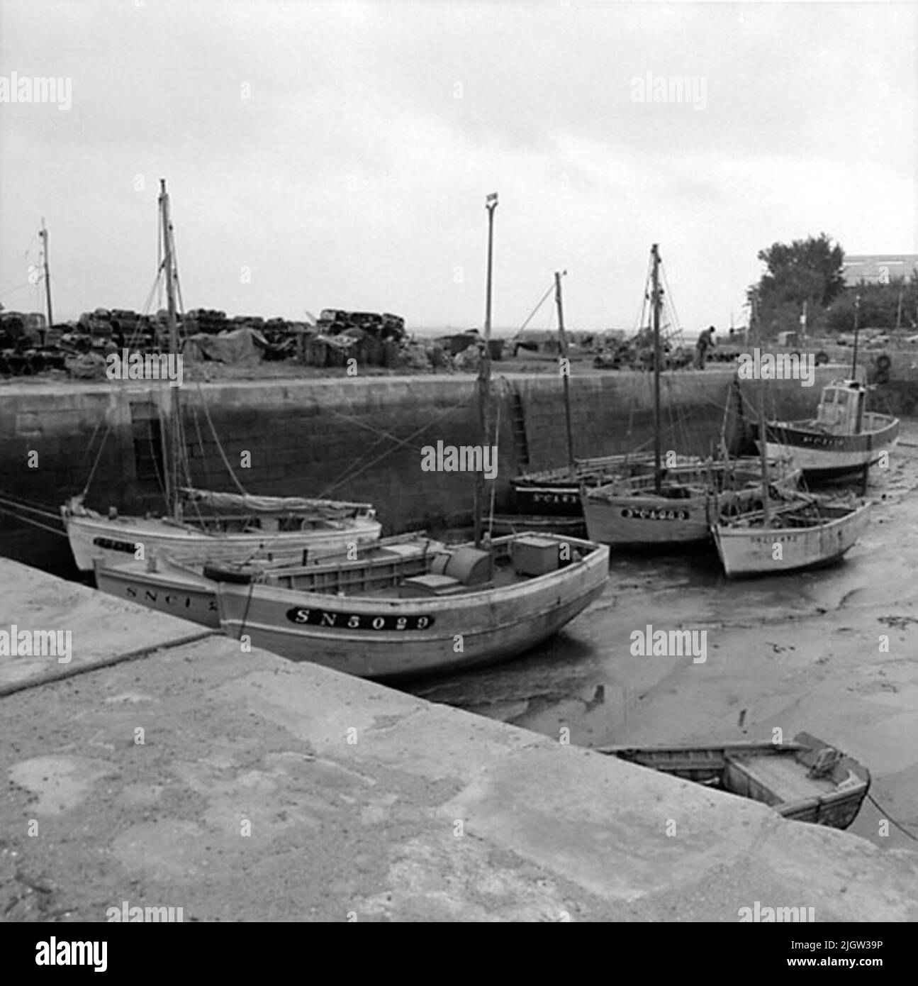 11. France. Photo journal is available at B.M.A. + Photo albums. Acquisition: Books and archive materials. Photos taken 1959-10-17.12 Pictures in series. According to notes: France. Atlantic coast, Le Croisic, 17/10 -59. Boats at EBB in the harbor. A several boats are located in a port in a community. There is low tide, so the boats are at the bottom of the harbor basin. On the quay are a number of fishing gear. Stock Photo