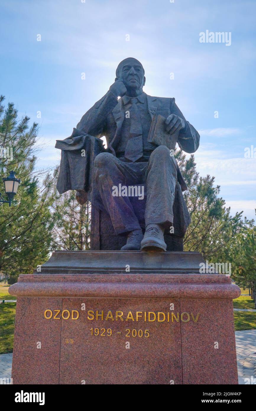 A bronze statue of a sitting Ozod Sharafiddinov, famous writer and critic. At Alisher Navoi National Park in Tashkent, Uzbekistan. Stock Photo
