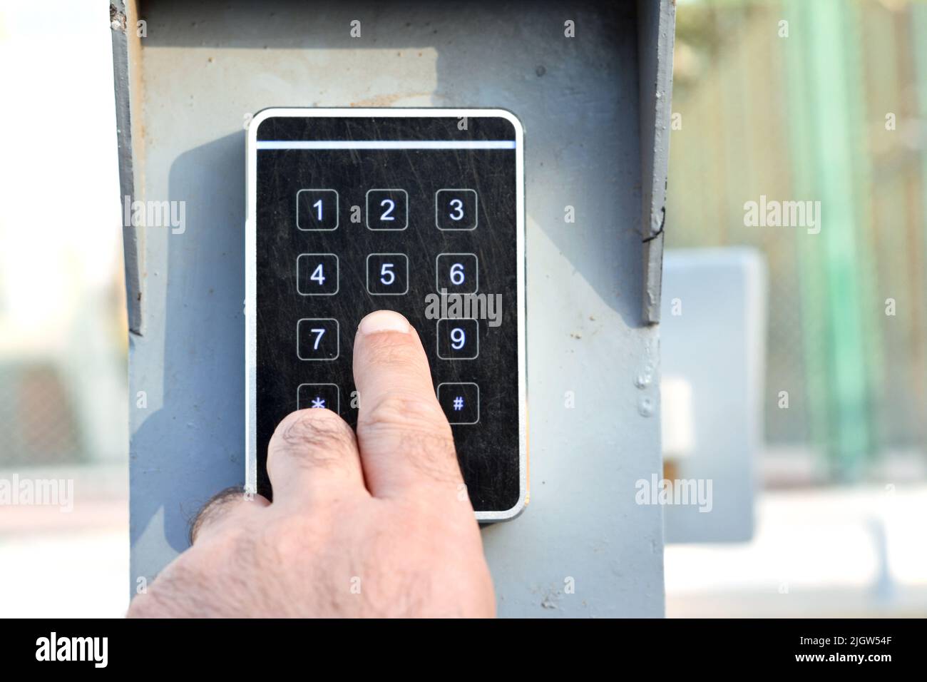 a persons hand pressing a password on a numerical keypad to lock or