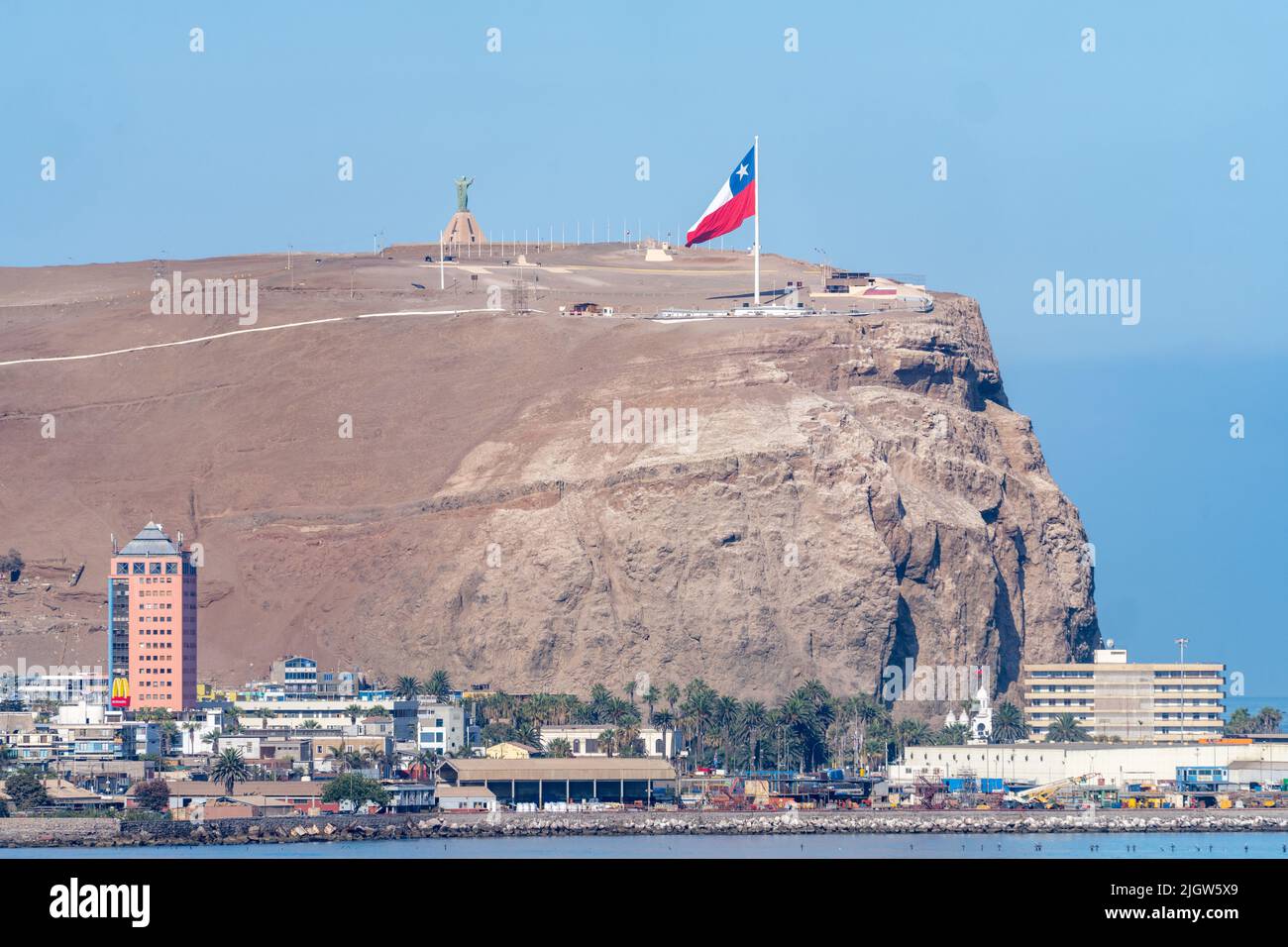 El Morro hill with its giant Chilean flag and Christus statue overlooks the city of Arica, Chile. Stock Photo