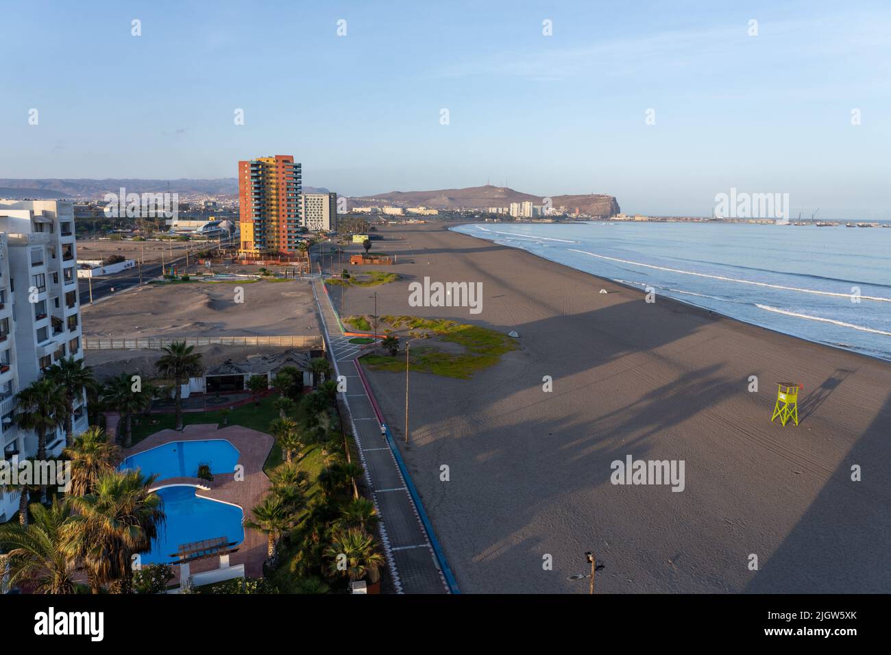 The deserted beach at sunrise in Arica, Chile with the El Morro hill in the background. Stock Photo