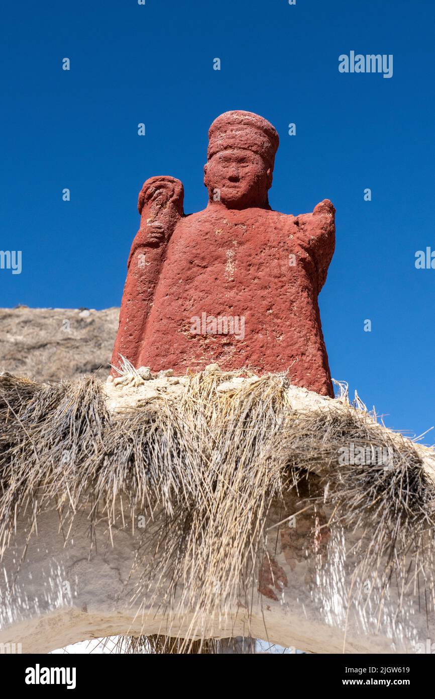 A very old carved stone statue of a bishop over the entry arch to the Church of the Virgin of the Nativity in Parinacota, Chile. Stock Photo