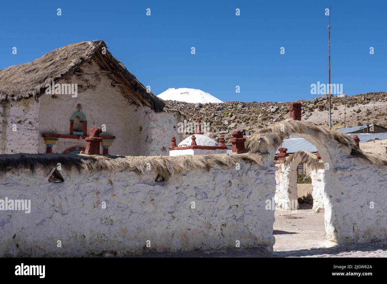 An arched entryway into the grounds of the Church of the VIrgin of the Nativity in the village of Parinacota in Chile.  Behind is the snow-capped peak Stock Photo