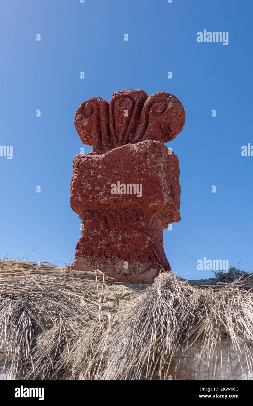 A very old carved stone statue on the outside wall of the Church of the Virgin of the Nativity in Parinacota, Chile. Stock Photo