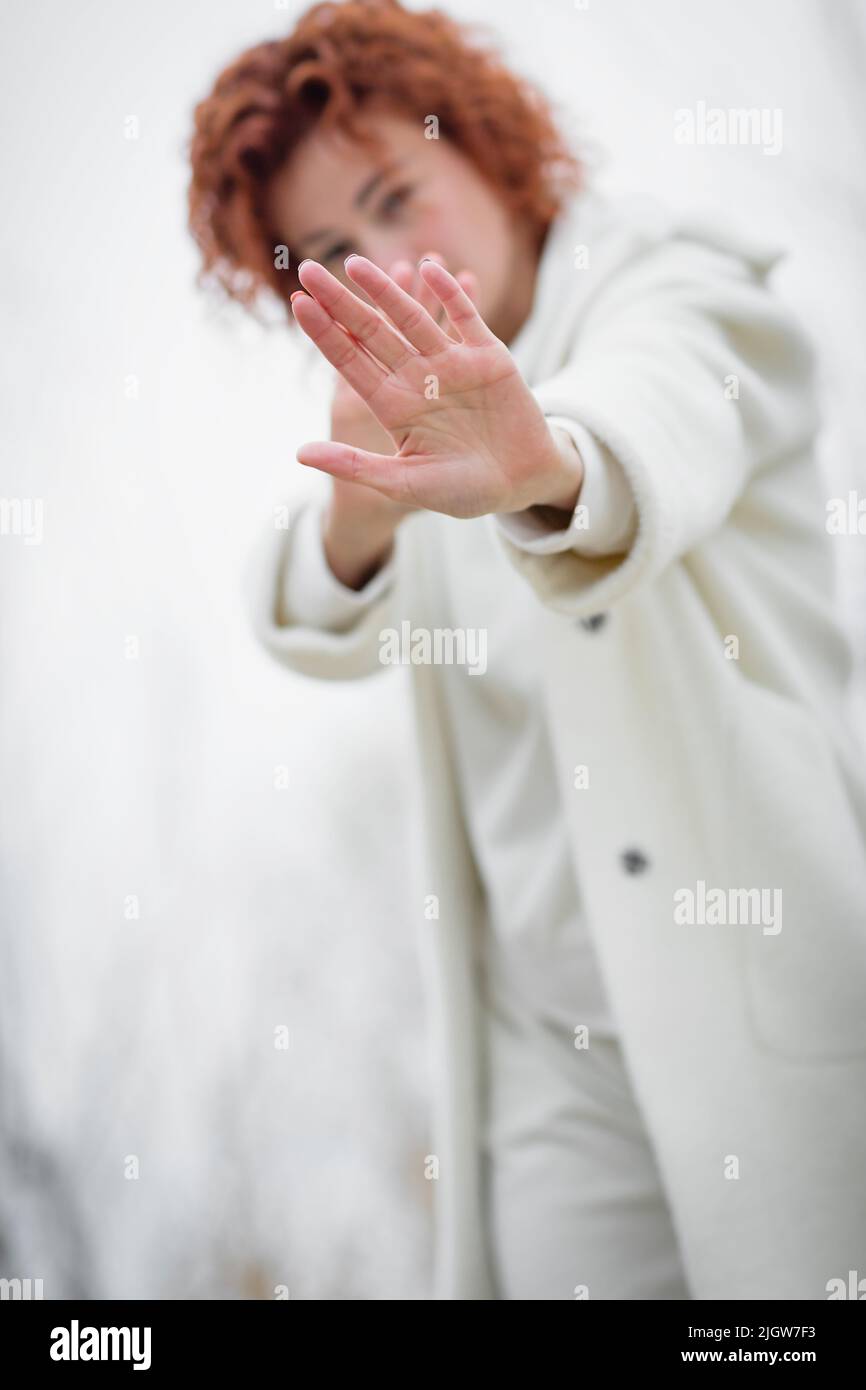 Close up focus on Redhair woman is looking at camera and showing stop gesture Stock Photo