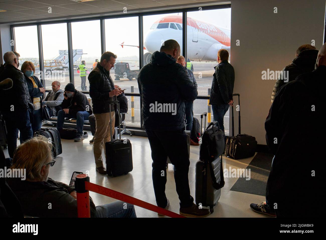 speedy boarding section of easyjet passengers waiting for aircraft flight depature at belfast international airport uk Stock Photo