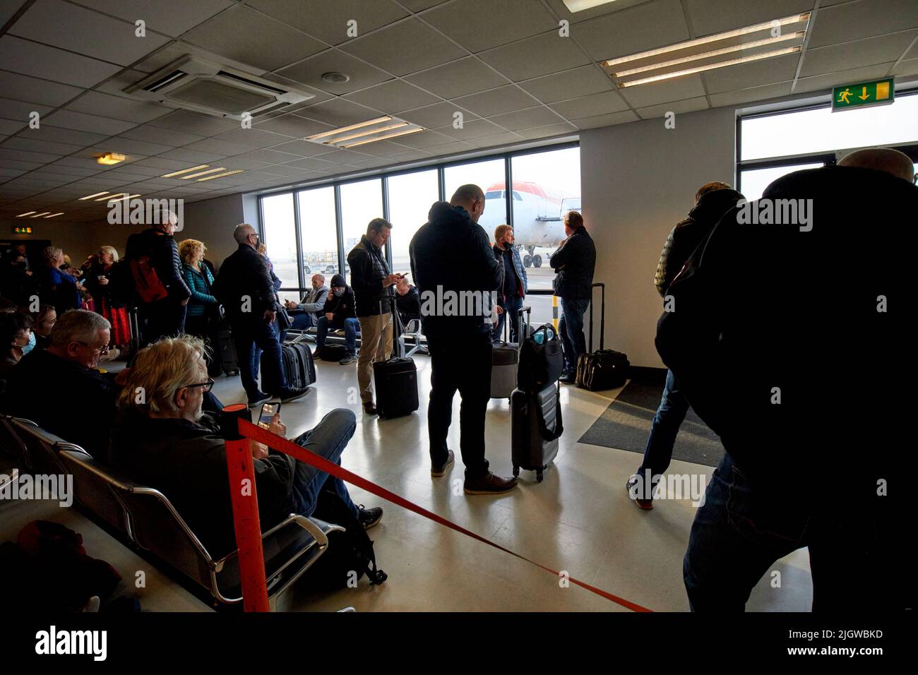 speedy boarding section of easyjet passengers waiting for aircraft flight depature at belfast international airport uk Stock Photo
