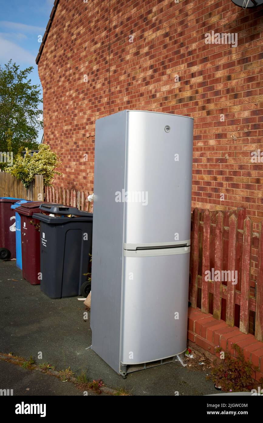 old broken fridge freezer left outside for council recycling pickup in the uk Stock Photo