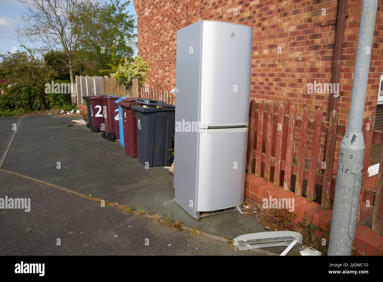old broken fridge freezer left outside for council recycling pickup in the uk Stock Photo