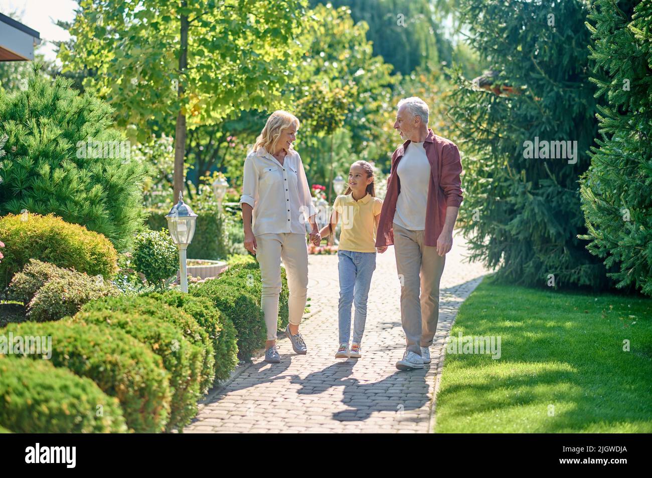 Happy family walking hand in hand in the park Stock Photo - Alamy