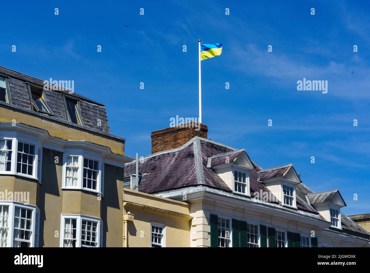 The Ukraine flag flies as a gesture of support, above buildings gs on Broad Street, Oxford, UK. Stock Photo