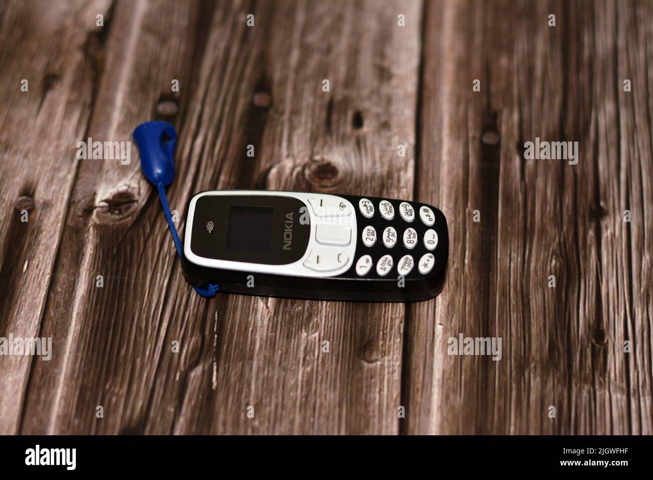 Cairo, Egypt, June 11 2022: A tiny small mini Nokia cell phone, an old classic smart small sized phone with a classic keypad and regular screen isolat Stock Photo