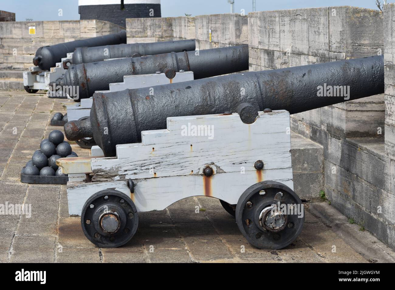 A row of medieval cannons and cannon balls on the ramparts of Southsea Castle. Stock Photo