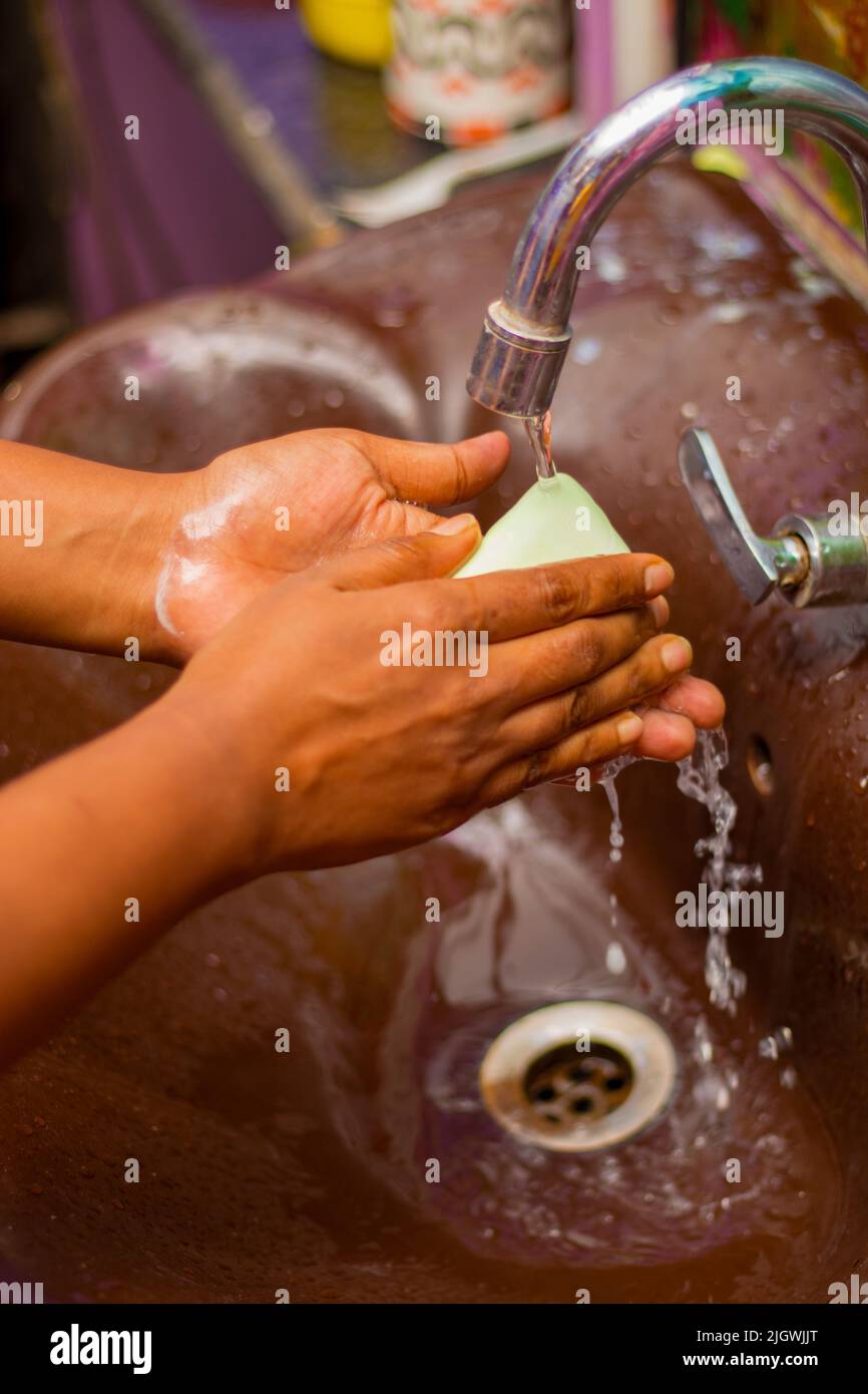 a lady washing her hands by soap to maintain hygiene.stay healthy.avoid germ and virus. Stock Photo