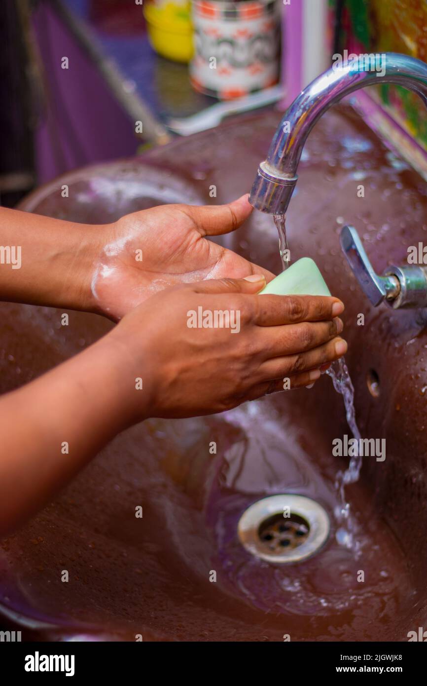a lady washing her hands by soap to maintain hygiene.stay healthy.avoid germ and virus. Stock Photo