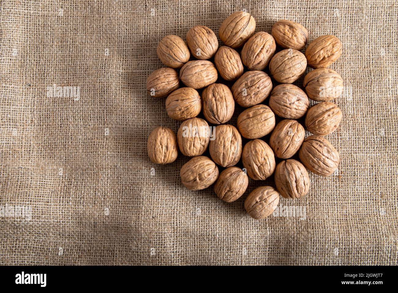 Whole walnuts on burlap sack,closeup Stock Photo