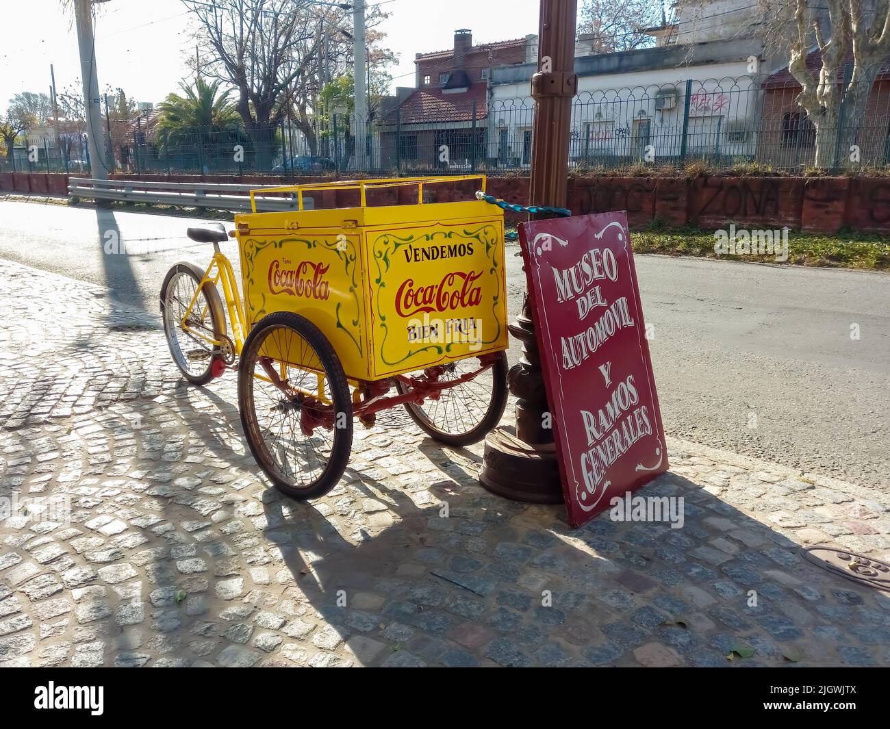 Old beverage vending cargo bike on the cobblestone. Delivery trike. Coca Cola logo and brand with traditional fileteado ornaments. Automobile Museum Stock Photo