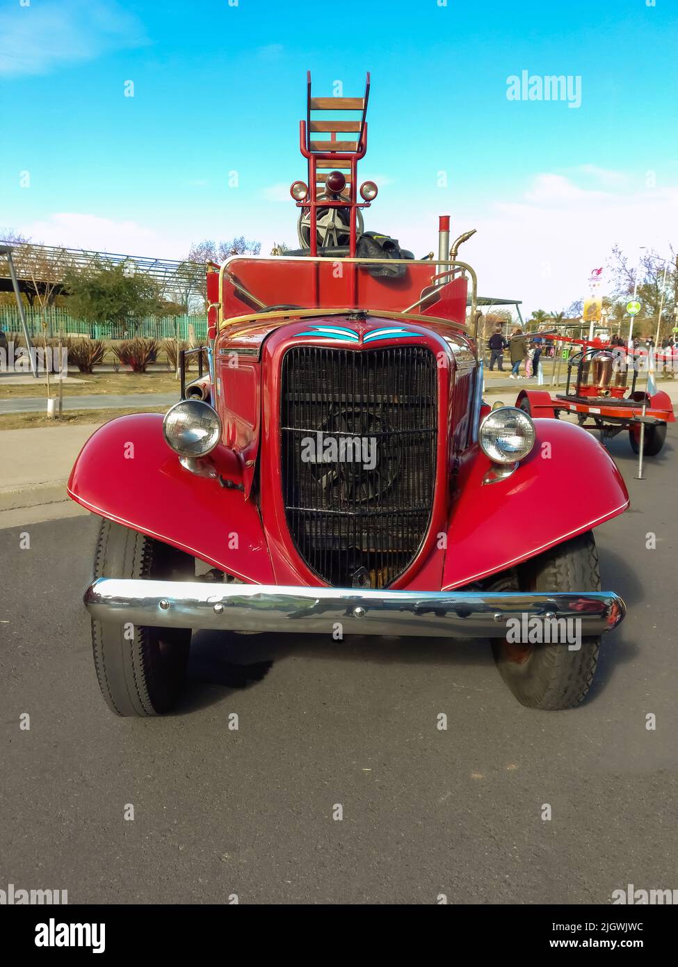 Shot of an old red 1936 Ford model 51 V8 fire truck pumper tanker. Front view. Grill. Ladder. Classic car show. Stock Photo