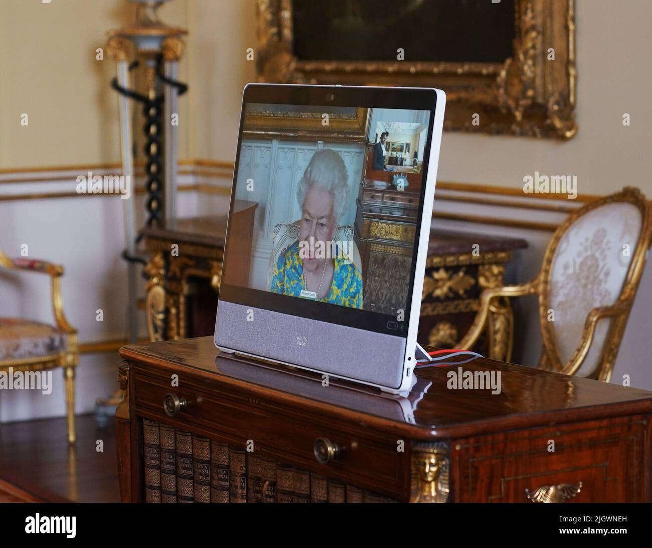 Queen Elizabeth II, in residence at Windsor Castle, appears on a screen via videolink, during a virtual audience to receive Thandazile Mbuyisa, High Commissioner for the Kingdom of Eswatini, at Buckingham Palace, London. Picture date: Wednesday July 13, 2022. Stock Photo