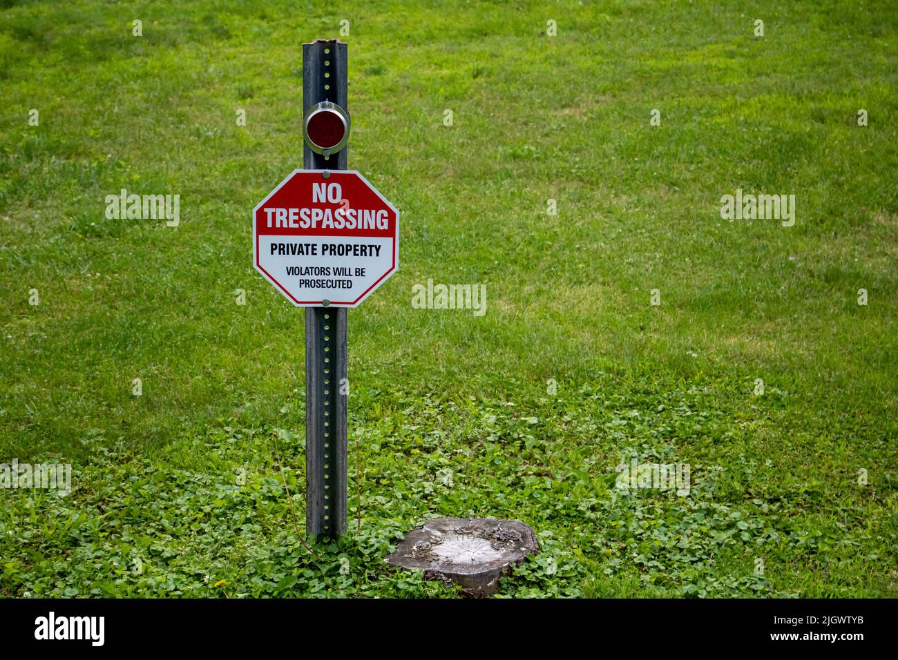 signs and symbols hexigon shapped message on a grass lawn. no trespassing  private property Stock Photo