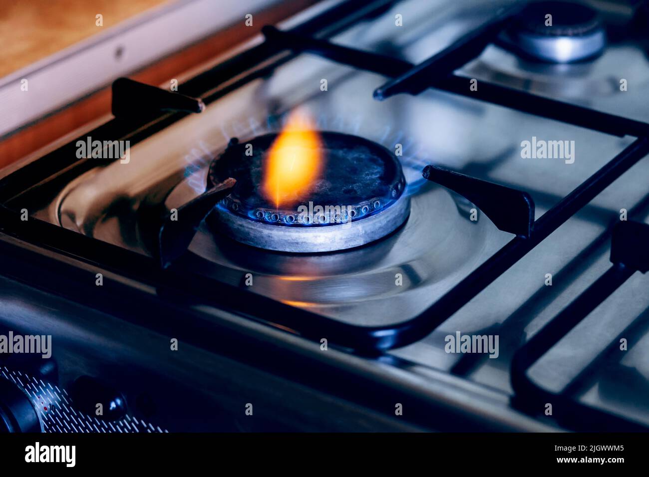 Kitchen gas hob, stove cook with blue and orange flames burning Stock